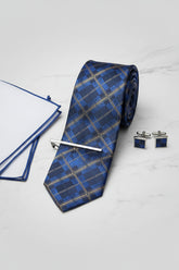 Navy and gold plaid silk tie with tie clip, accompanied by white pocket square.